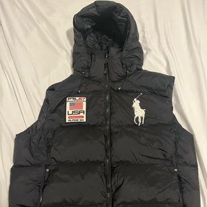 Big winter puffer jacket by Polo Ralph Lauren. Its black and has a iconic badge.